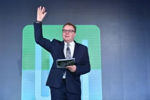 Greg Clark speaking on stage at an urban development conference while addressing an audience.