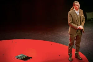 Mikko Hyppönen speaking about cybersecurity and AI threats during a TED Talk conference presentation