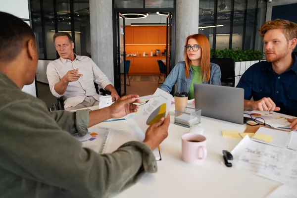 Diverse business team reviewing reports and discussing strategy during a collaborative office meeting