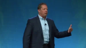 Bill Benjamin speaking on stage with arms extended during his keynote on emotional intelligence